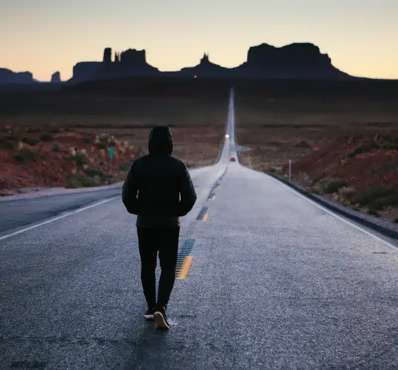 person walking in the center of the road